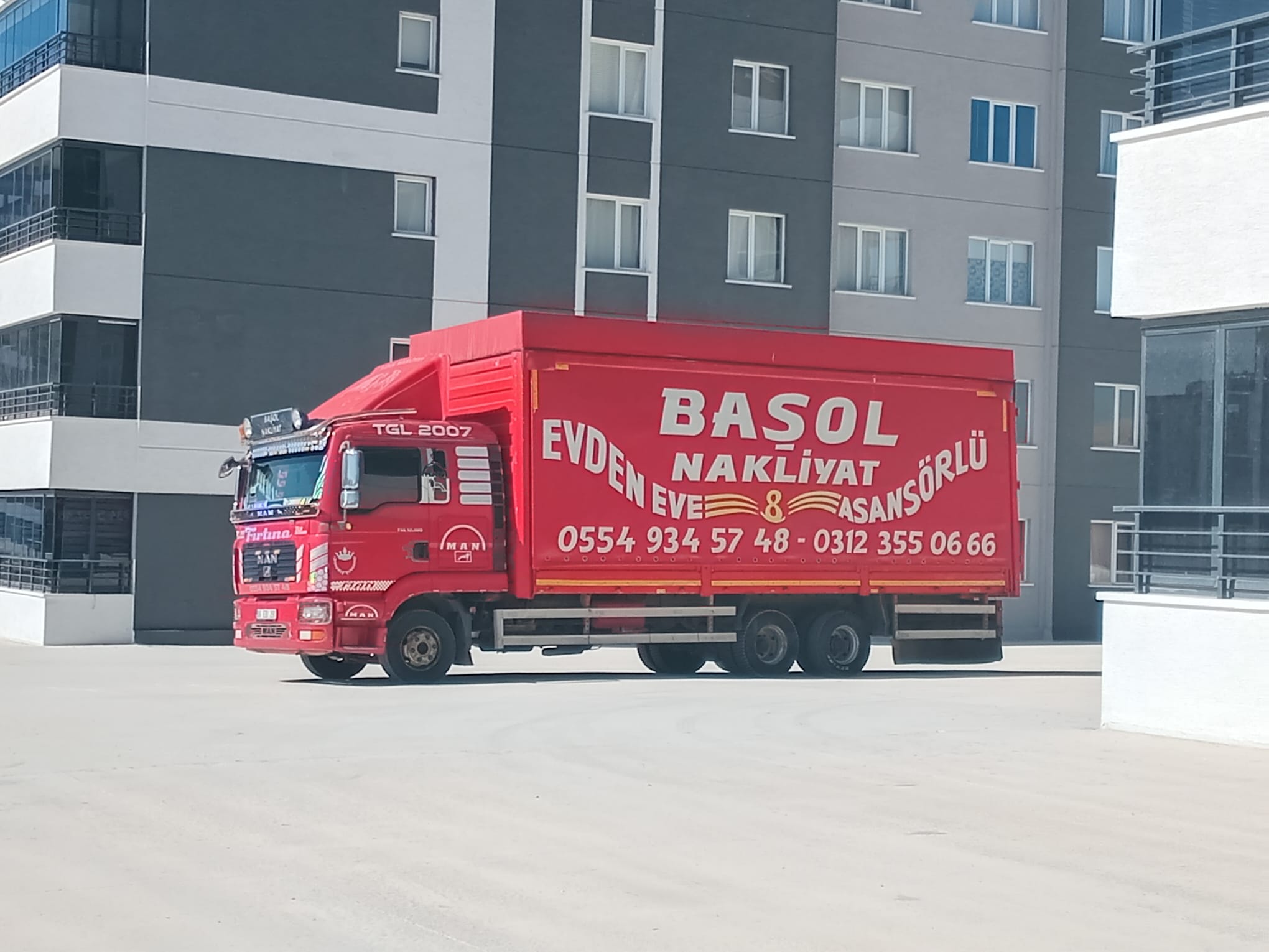 Ankara Nakliyat - Basol Nakliyat Kırmızı nakliyat kamyonu modern apartmanlar önünde